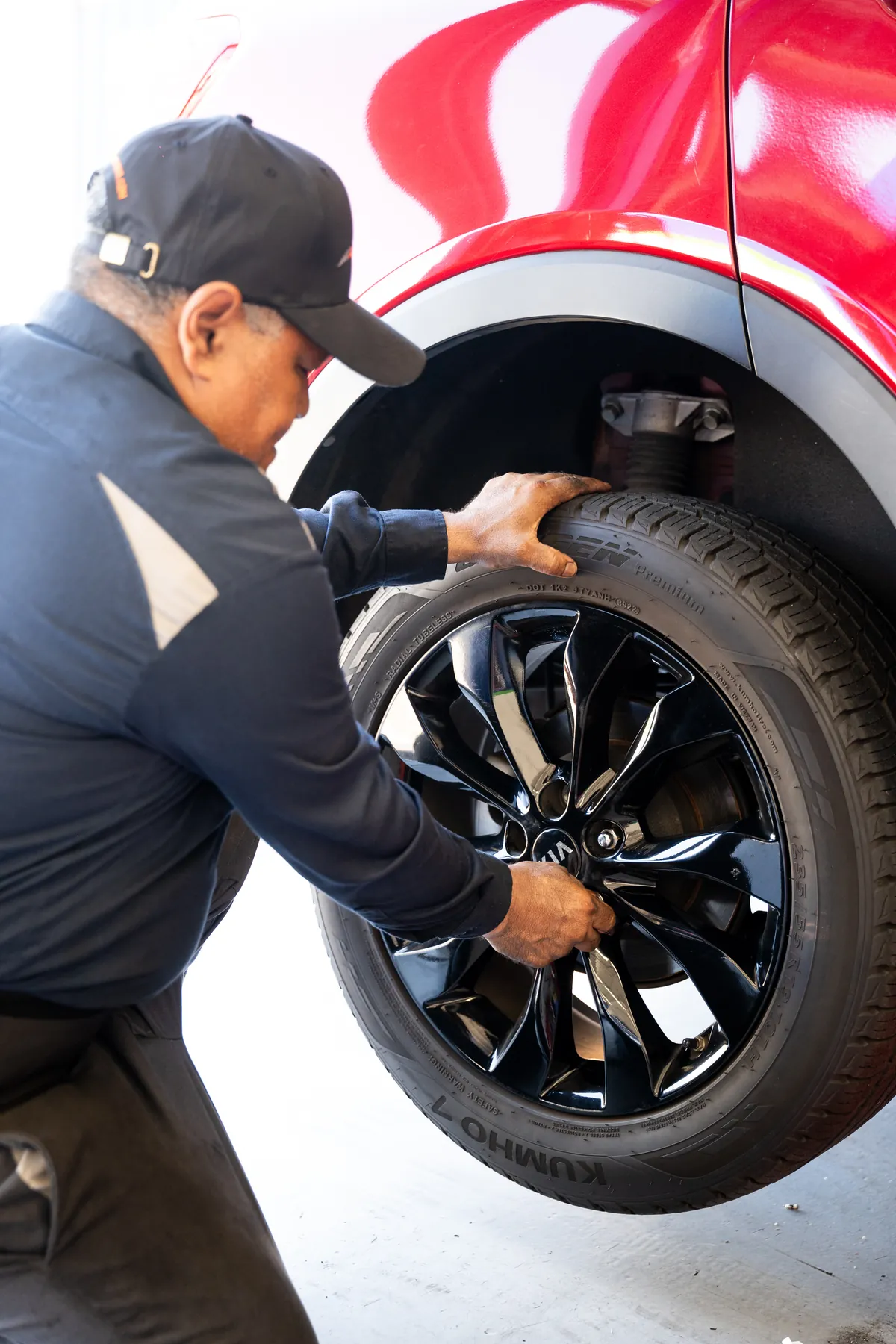 Technician pulling a wheel off an SUV to fix a flat