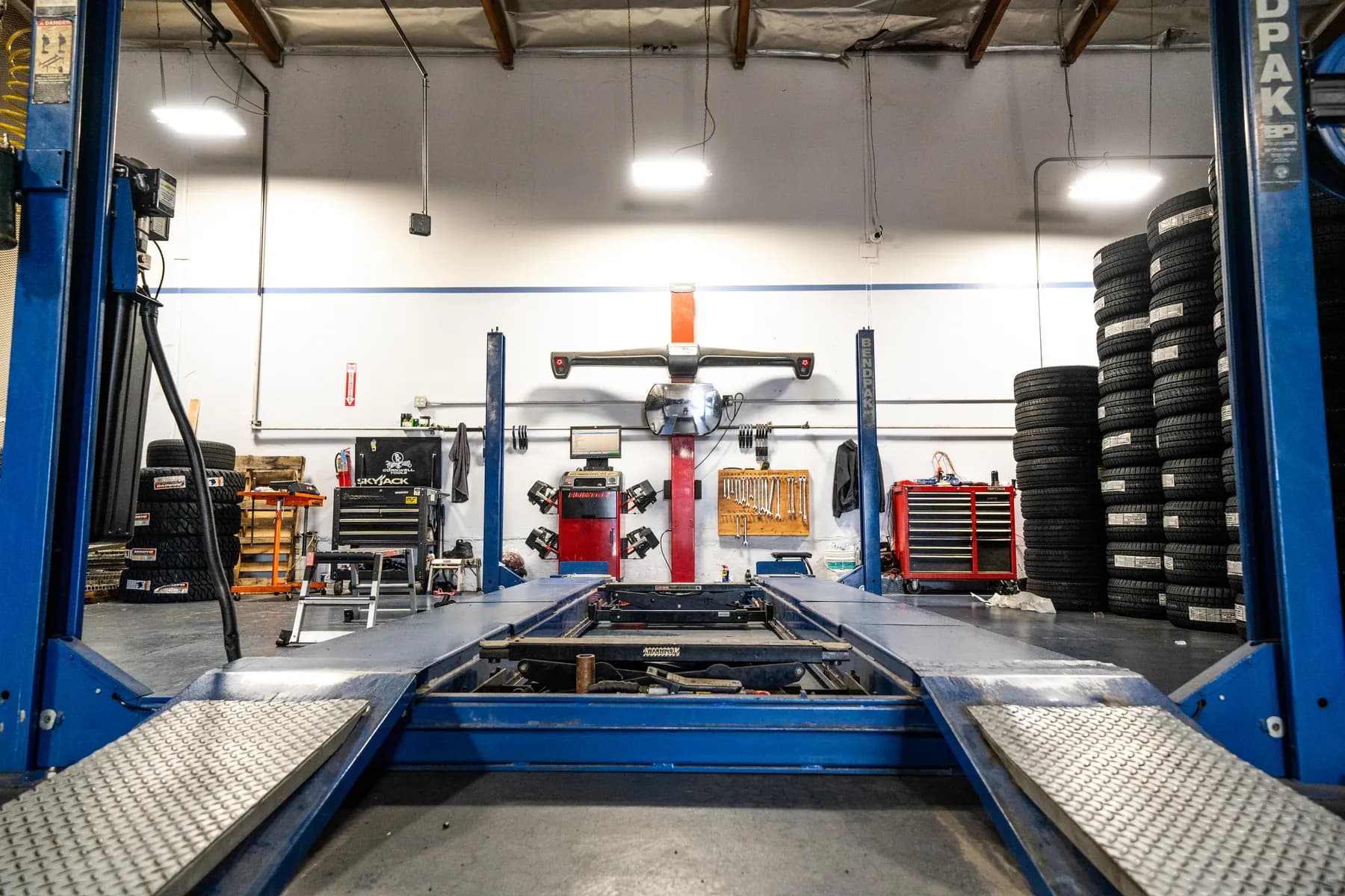 Alignment bay with the rack, alignment machine and tires stacked against the wall