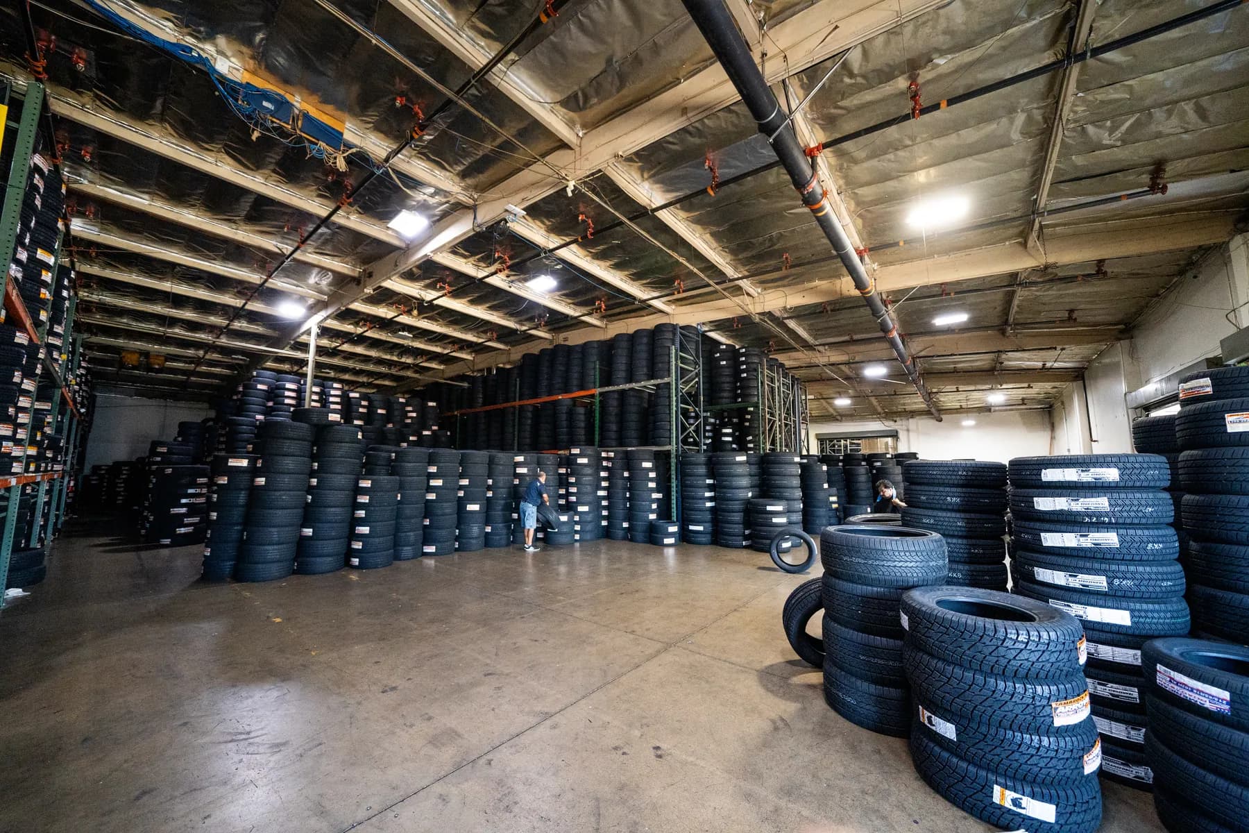 Warehouse floor stacked high with new tires