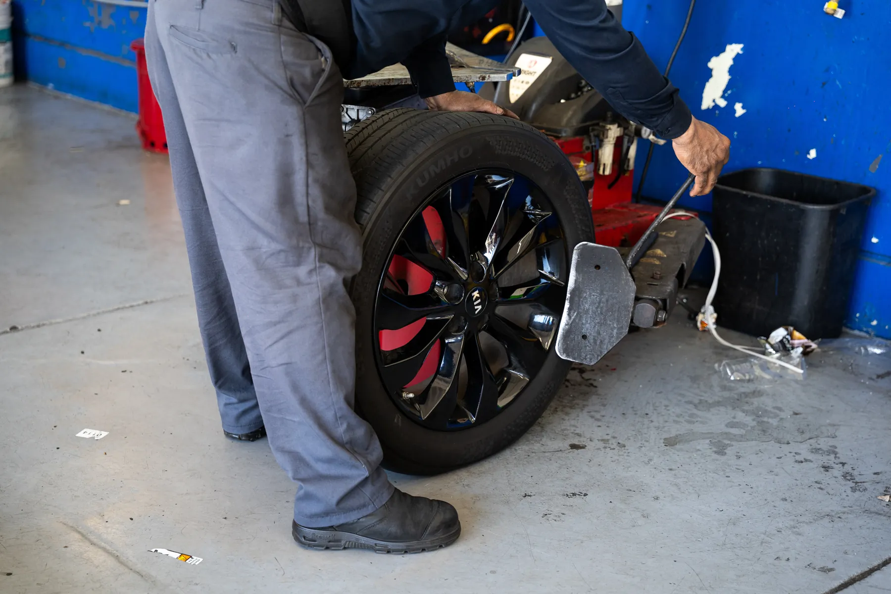 Technician mounting a wheel and tire on the balancer