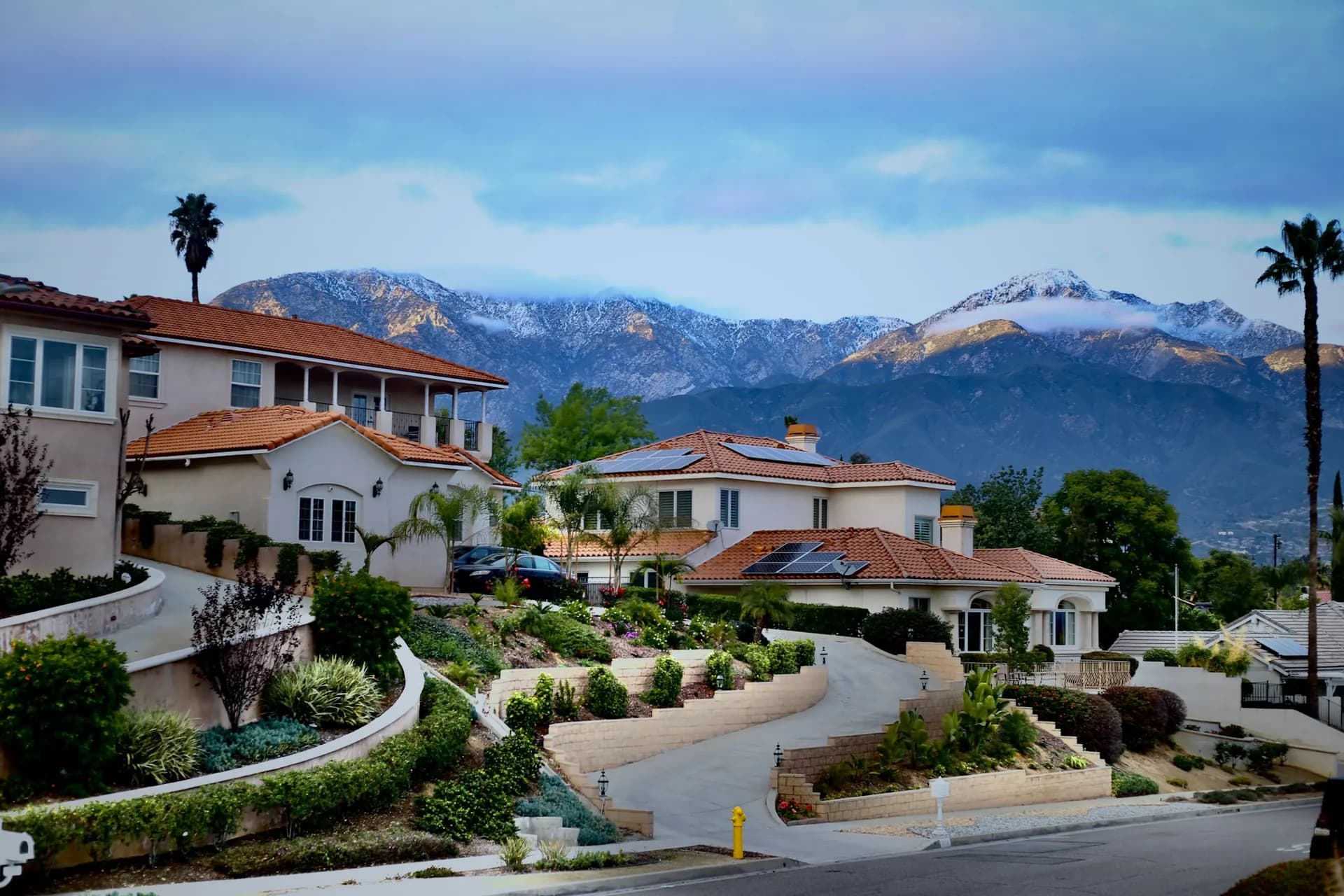 Upland hillside street with the snowy San Gabriel Mountains behind